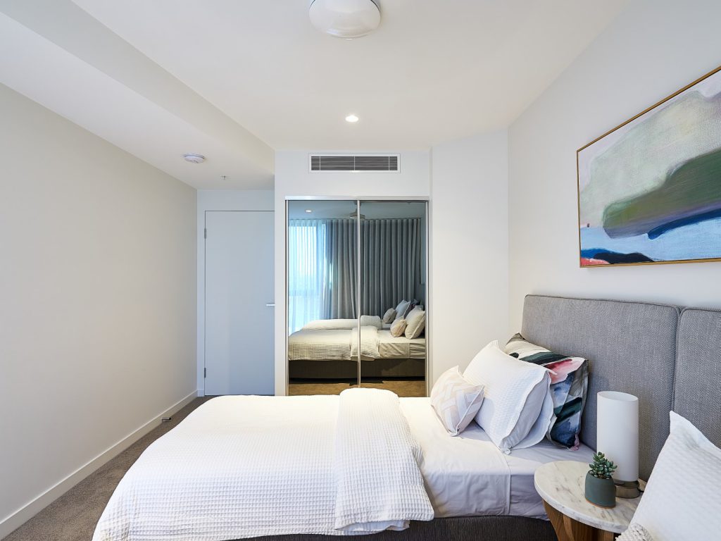 mirrored wardrobe opposite a bed